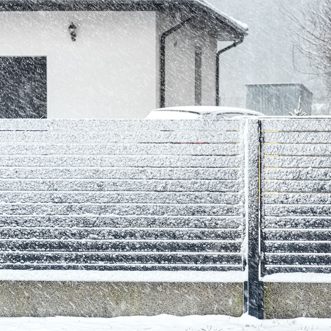 Midwest winter snow covering a panel fence in residential neighborhood