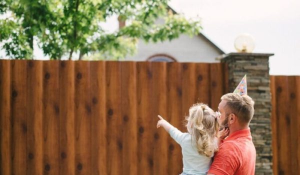 Young girl pointing at backyard fence in Indianapolis home