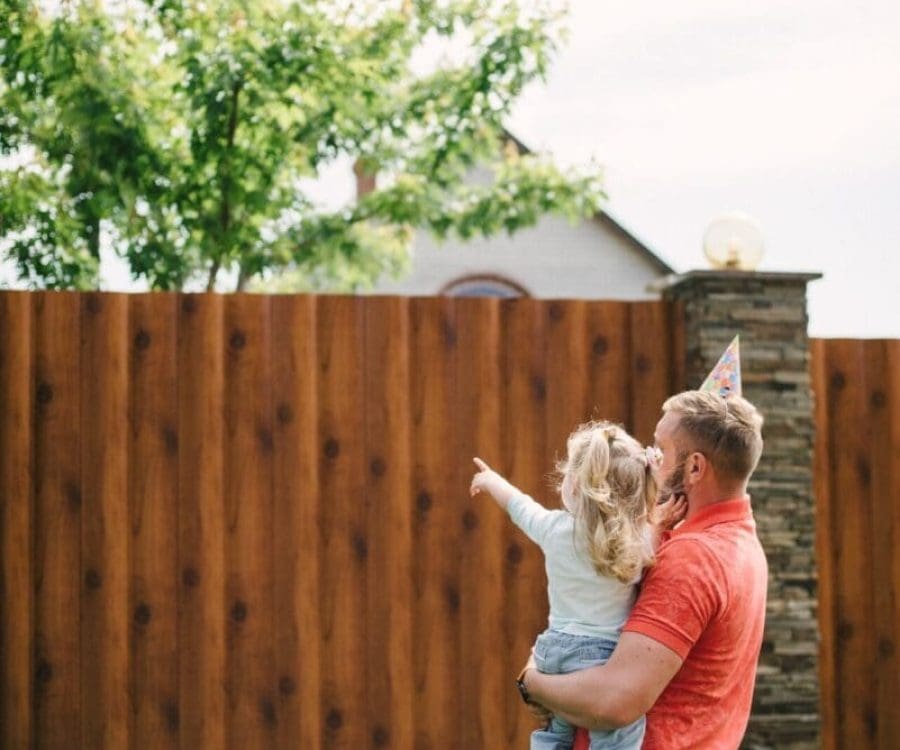 Young girl pointing at backyard fence in Indianapolis home